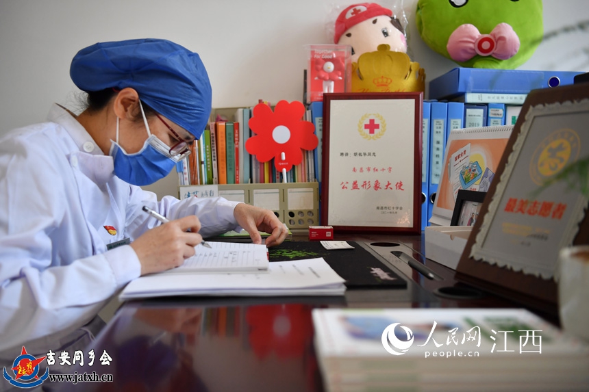 在办公桌前，胡敏华正在整理艾滋病患者的相关资料。 人民网 时雨摄