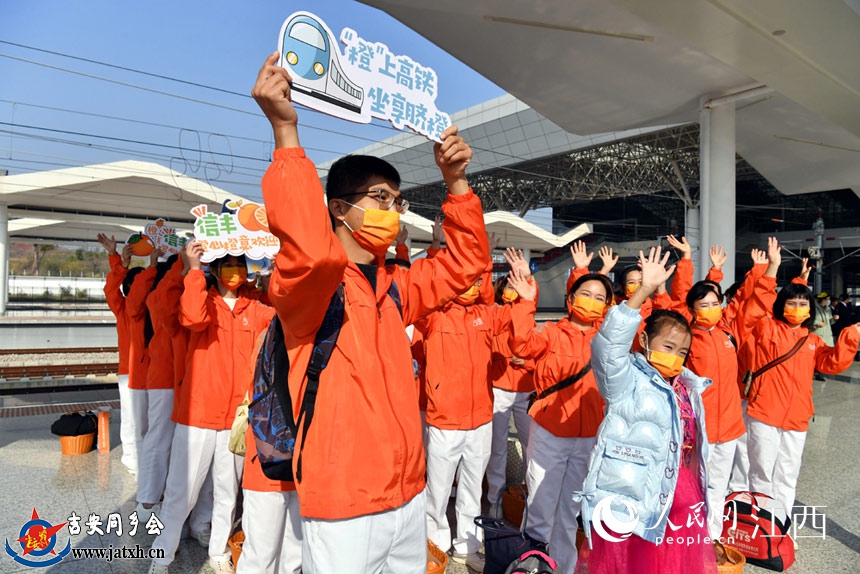志愿者在高铁站台迎接“世界橙乡 赣州信丰”号高铁进站。 人民网 时雨摄