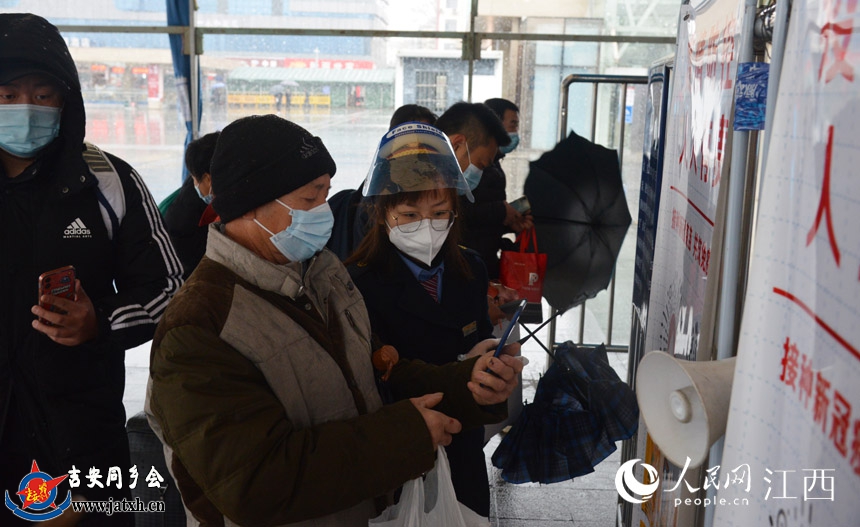 九江车务段工作人员在进站口协助旅客扫防疫行程码，方便旅客快速进站。杨锐 摄